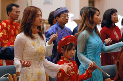 St. Joseph parishioners Jennie Le, from left, Anna Le and Celina Le of Indianapolis hold hands for the Lord’s Prayer during the archdiocesan World Mission Sunday Mass on Oct. 19 at SS. Peter and Paul Cathedral in Indianapolis. They participate in the Vietnamese Apostolate at St. Joseph Parish in the Indianapolis West Deanery. (Photo by Mary Ann Wyand) 