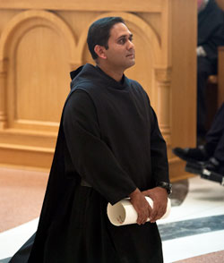 Benedictine Novice Anushka Fonseka kneels in prayer on Aug. 6 during a liturgy in the Archabbey Church of Our Lady of Einsiedeln at Saint Meinrad Archabbey in St. Meinrad in which he professed temporary vows as a Benedictine monk. He is holding a handwritten document that records his vows. (Photo courtesy of Saint Meinrad Archabbey)