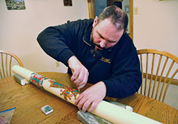 Father Aaron Jenkins, pastor of St. Michael Parish in Greenfield, puts the final touches on March 23 on an Easter candle that he decorated that is being used in his Indianapolis East Deanery faith community. (Photo by Sean Gallagher)