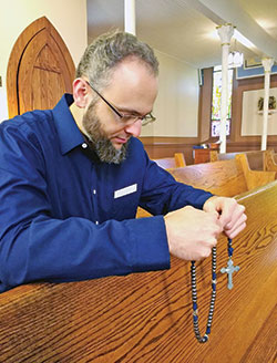 Sam Bunch prays using a skull rosary inside Annunciation Church in Brazil. (Submitted photo by Daniel Tews)