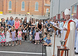 Members of St. Nicholas Parish in Ripley County and students at the faith community’s school listen on Aug. 4 as Archbishop Charles C. Thompson preaches during a liturgy to bless the parish’s new education center. (Photo by Sean Gallagher)