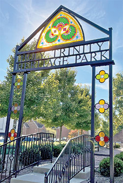 Sunlight streams through a restored, 132-year-old stained-glass window that survived a devastating fire that destroyed the former Holy Trinity Church in New Albany. The window now welcomes visitors to Holy Trinity Heritage Park in New Albany. The structure and a new statue were blessed by Father Wilfred “Sonny” Day on Oct. 4. (Submitted photo courtesy of St. Elizabeth Catholic Charities in New Albany)