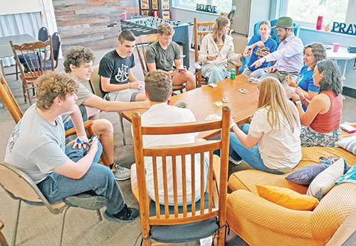 High school youths from St. Joseph Parish in Corydon and St. Mary Parish in Lanesville join together with NET missionaries on Sunday evenings for faith discussions, fellowship, food and eucharistic adoration. Here, the connection between the youths and the young adult missionaries shows as they play a game of Uno. (Submitted photo)