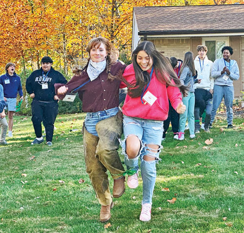 As part of an icebreaker for high school participants in the Student Leadership Program at Our Lady of Fatima Retreat House in Indianapolis, Reaghan Boland, left and Fatima Hernandez show their joy in competing in a three-legged race on Oct. 27. (Submitted photo)