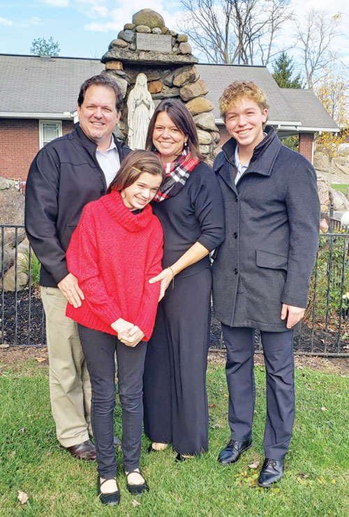 Joshua, left, Kathryn, Laura and Levi Marszalek, members of St. Gabriel Parish in Connersville, pose in front of the parish’s Marian grotto on Nov. 24. The family’s faith has been enhanced through Kathryn’s early diagnosis of Alternating Hemiplegia of Children, or AHC, an extremely rare neurological disorder. (Photo by Natalie Hoefer)