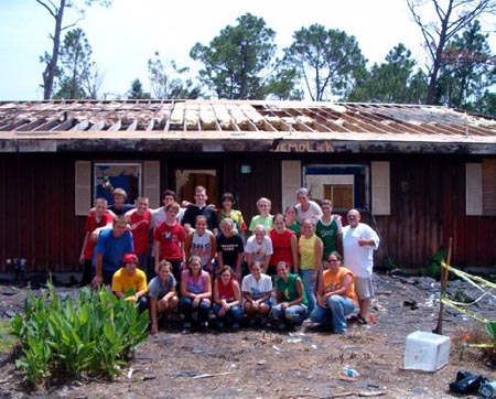 Homeowner Don and volunteers with house partially demoed