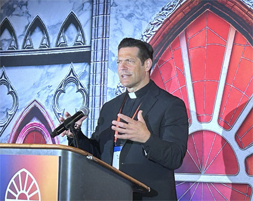 Father Mike Schmitz, director of Youth and Young Adult Ministry for the Diocese of Duluth, Minn., as well as the chaplain for the Newman Center at the University of Minnesota-Duluth, speaks to media at the National Eucharistic Congress in Indianapolis July 18. Father Schmitz is also the host of the popular Ascension podcasts "Bible in a Year" and "Catechism in a Year." (OSV News photo/Gretchen R. Crowe)